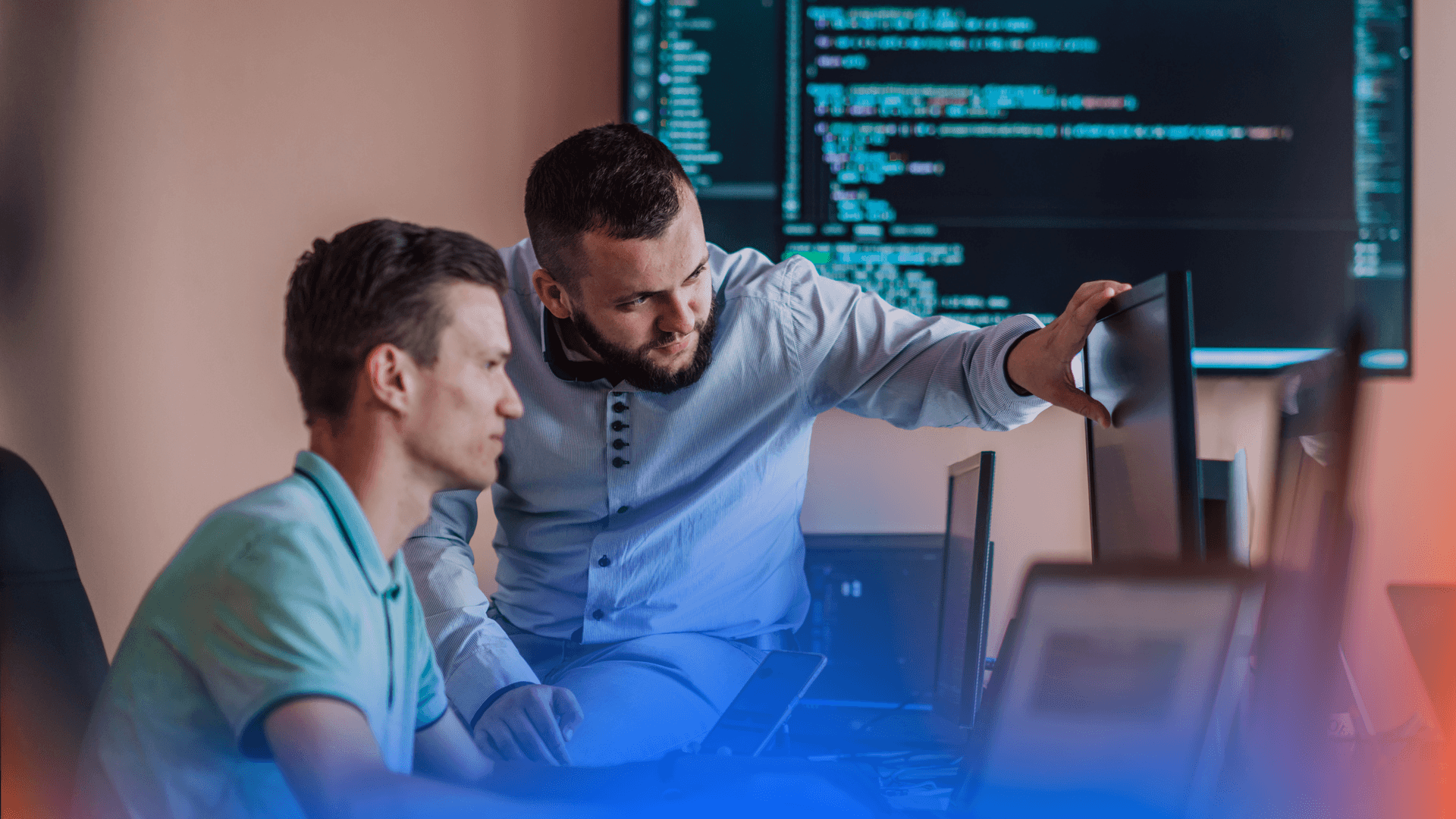 Two java developers inspecting code with a big screen with Java code in the background